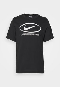 Černé bavlněné tričko s krátkým rukávem, které má výrazné bílé logo Nike a pod ním tučný text "Nike Sportswear".