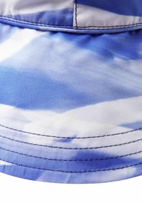 Blue and white tie-dye bucket hat made of fabric with a smooth texture, featuring visible stitching along the brim and top seam.