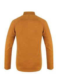 Halenka s dlouhým rukávem v hořčicově žluté barvě, vyrobena z texturované látky. Má vysoký límec a raglánové rukávy s kontrastním švem.