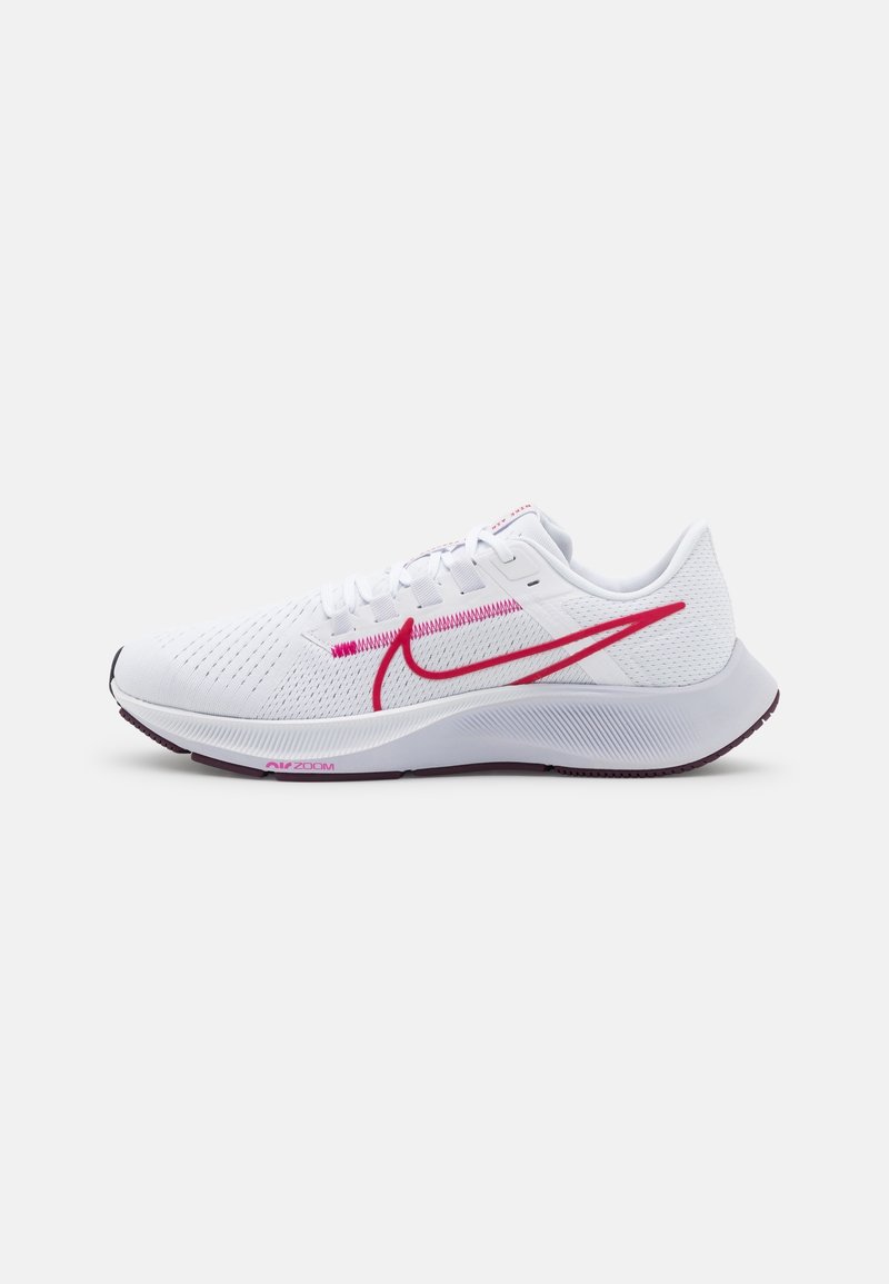 Baskets de course blanches avec le logo Swoosh rose de Nike, lacets blancs et upper en maille texturée sur un fond blanc.