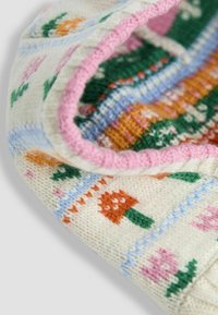 Pletená krémová látka s viacfarebnými kvetinovými vzormi, vrátane oranžových a ružových kvetov, lemovaná ružovým rebrovaným okrajom.