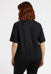 Black short-sleeve shirt with a smooth texture, relaxed fit, and rolled cuffs. The back features a rounded hem and a simple design.