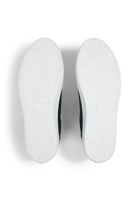 Baskets noires avec une tige lisse et une semelle extérieure en caoutchouc blanc. La semelle extérieure présente des motifs de grip texturés et un logo embossé.