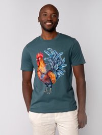 Teal katoenen t-shirt met een kleurrijke haan grafiek met gedetailleerde veren. Korte mouwen en een ronde halsontwerp.
