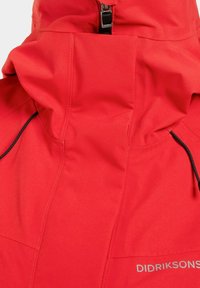 Röd vattentät jacka med hög krage, svart dragkedjeklös och Didriksons-logotyp på bröstet.
