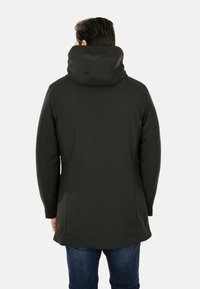 Parka isolante nero con colletto alto e cappuccio, caratterizzata da una finitura liscia opaca e una vestibilità comoda, progettata per garantire calore in condizioni di freddo.