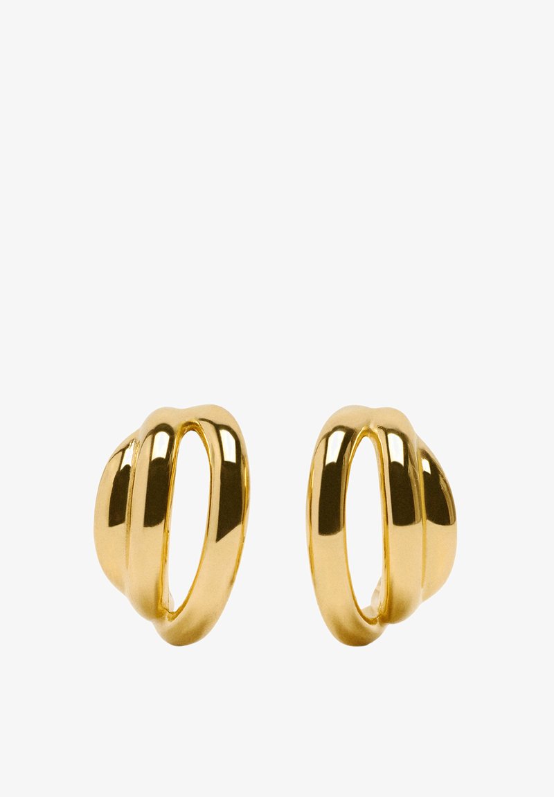 Złote kolczyki w kształcie obręczy o gładkim, wypolerowanym wykończeniu, z falistym wzorem i pustymi sekcjami, tworzące nowoczesny wygląd.
