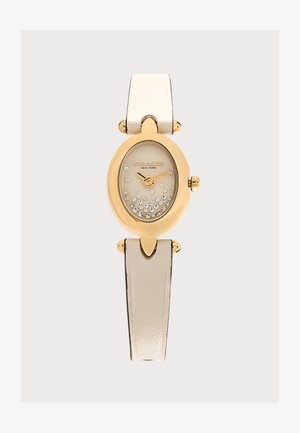 Reloj de pulsera ovalado color dorado de Coach con esfera champán, detalles de cristal y correa de piel beige metalizada.