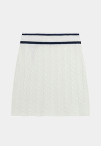 Jupe blanche en tricot torsadé avec une taille côtelée présentant des rayures bleu marine. Design simple en A avec des motifs texturés sur toute sa surface.