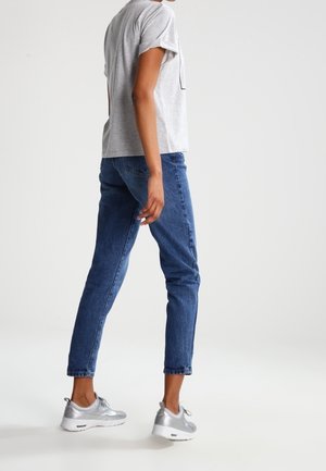 T-shirt grigio a maniche corte, jeans in denim blu e sneakers argento; design casual con forme ben definite e linee pulite.
