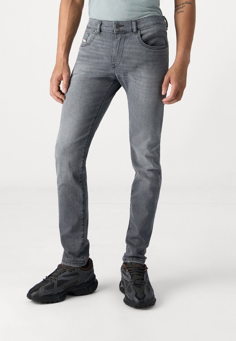 Grå slim-fit jeans i denim med fem fickor och subtila blekningar. Bärs med svarta sportskor.