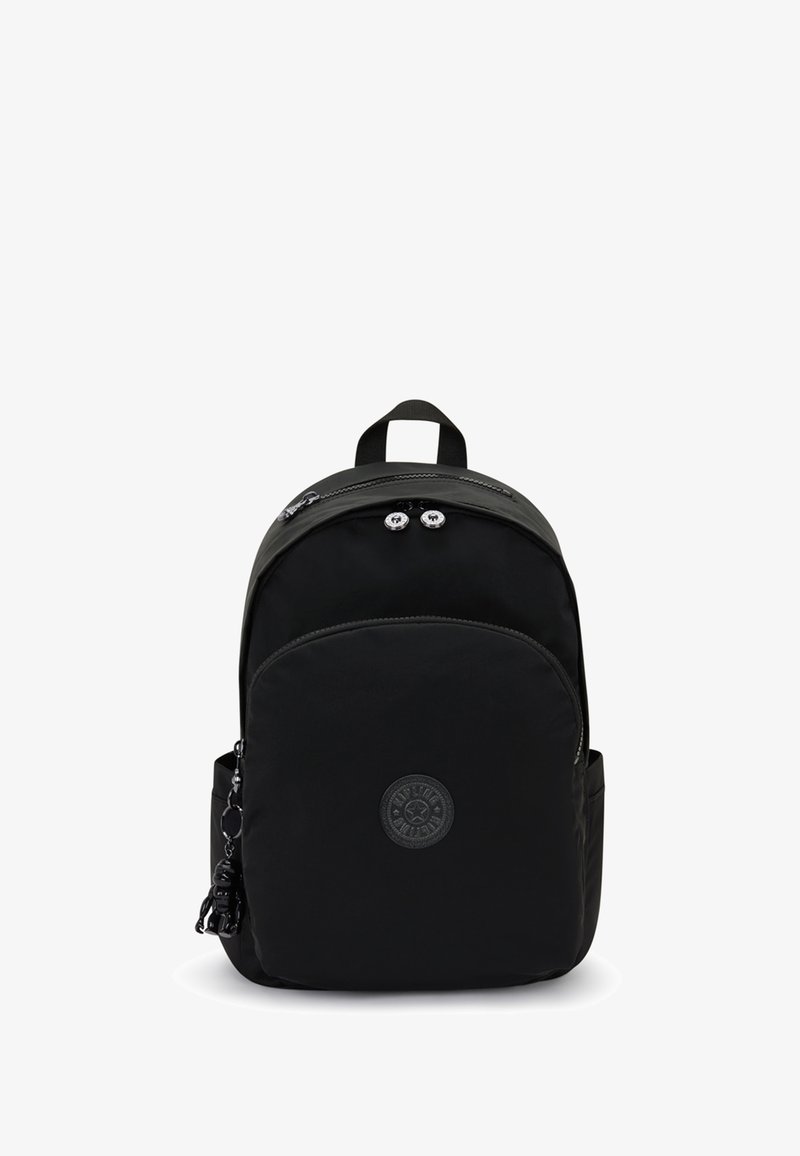 Zaino in nylon nero con forma arrotondata, scomparto principale con zip, tasca frontale e un'etichetta con logo rotondo. Include un portachiavi decorativo.