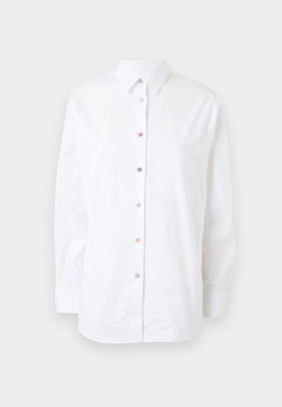 Λευκό ανοιχτόχωρο πουκάμισο με μακριά μανίκια από βαμβάκι. Διαθέτει κουμπιά μπροστά σε χρώμα, τσέπη στο στήθος και κλασικό γιακά.