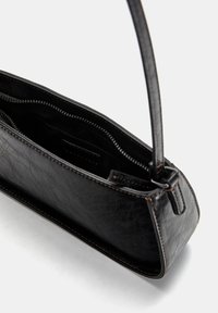 Zwarte leren tas met een gestructureerd oppervlak, een ritsluiting en een enkel handvat. Beschikt over contrasterende stiksels en een minimalistisch rechthoekig ontwerp.