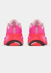 Par neonrosa och neonorange löparskor visade bakifrån, som framhäver vadderad krage och texturerad sula.