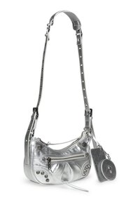 Bolso de mano metálico plateado con forma curva, superficie texturizada, correa ajustable, tachuelas decorativas y un pequeño bolsillo circular adjunto.