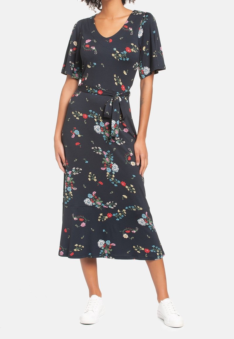 Blommönstrad klänning i mörk marinblå, med korta ärmar, v-ringning, knytmidja och en utsvängd kjol med en nederkant under knäet.