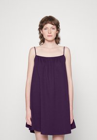 Vestido roxo sem mangas com um corte solto, apresentando alças finas, detalhes franzidos na gola e uma bainha reta. Textura de tecido suave.