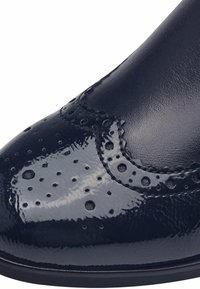 Marinblå lacklädersko med brogue-detaljer och perforeringar. Har en slät yta och rund tå. Svart sula.