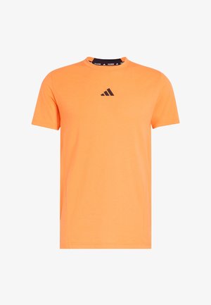 T-shirt d'entraînement Adidas orange à manches courtes avec logo Adidas noir centré sur la poitrine et bordure intérieure noire avec le texte "TRAINING".