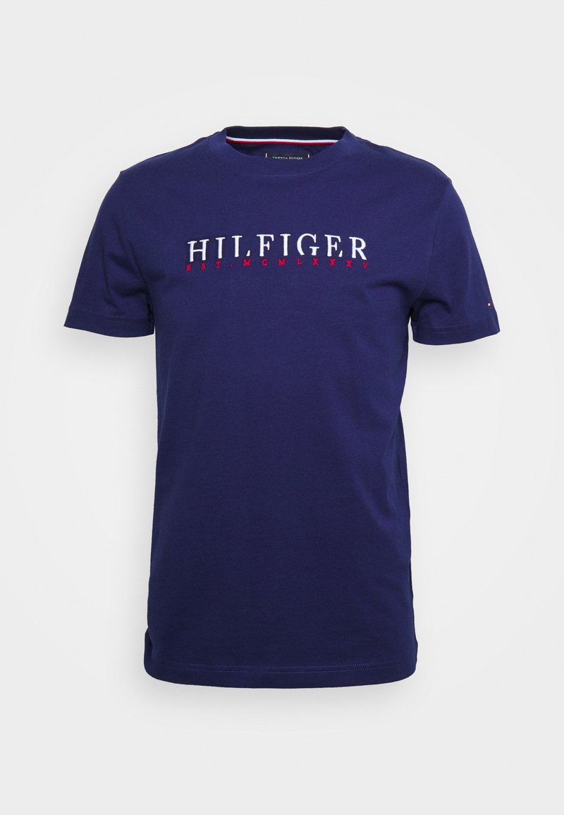 Námorně modré bavlněné tričko s krátkými rukávy, zdobené bílým a červeným vyšitým nápisem "HILFIGER" a kulatým výstřihem.