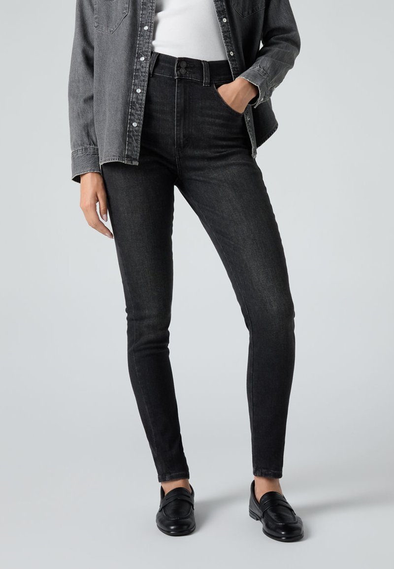 Mustat korkeavyötäröiset farkut, jotka on valmistettu puuvillasekoitteesta. Farkuissa on slim fit -leikkaus, nappisuljenta ja hentoa haalistumista. Yhdistetty mustien loaferien ja harmaan paidan kanssa.