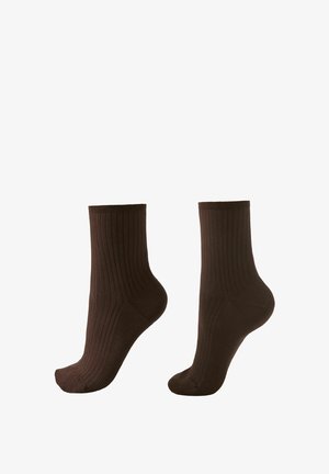 Chaussettes en coton marron avec une texture côtelée, longueur mi-mollet, bout sans couture et bord extensible. Conviennent pour un usage quotidien.