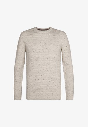 Vaaleanbeige neulepaita, jossa on tekstuurinen kuvio, pitkät hihat ja pyöreä pääntie. Hienovaraiset tummemmat väriläiskät korostavat kangasta.