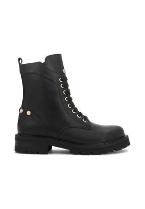 Botte de combat noire en cuir à lacets avec semelle épaisse, œillets métalliques et clous métalliques décoratifs au talon et sur la partie supérieure de la zone des lacets.