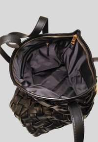 Borsa a mano in pelle intrecciata nera con un ampio interno in tessuto nero, dotata di chiusura a zip e tasche interne con accessori dorati.