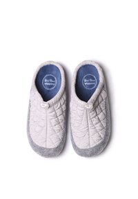 Chaussons matelassés gris et blanc avec un design arrondi, dotés d'un dessus en tissu, d'un intérieur doux bleu et d'un détail en bouton.