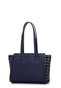 Navy tote bag with smooth synthetic leather body and textured woven fabric sides. Features dual long handles and subtle gold hardware accents.