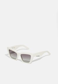 Bijele oversized sunčane naočale s mat površinom, angularnim dizajnom, gradient sivim staklima i suptilnim brendiranjem na dršci.