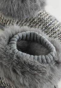 Grå strikket hjemmesko med en blød faux fur kant. Har et ribbet strikdesign og en plyssudsat inderside for komfort.