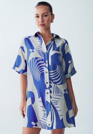Lyhythihainen nappilukollinen mekko kevyestä kankaasta, jossa on abstrakti sinivalkoinen kuosi, tasku ja rento istuvuus.