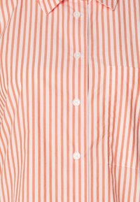 Orange and white vertically striped button-up shirt with a chest pocket and a pointed collar.