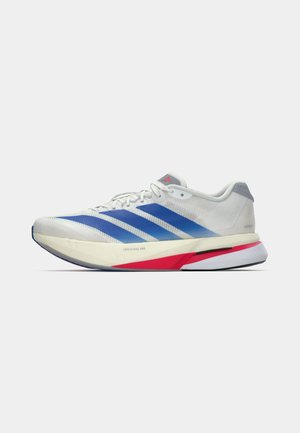 Chaussures de course légères blanches avec des rayures bleues, dotées d'une tige en mesh texturé, des accents rouges et gris, et une semelle amortie.