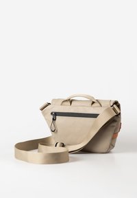 Beige Umhängetasche mit strukturierten Oberflächen, einem oberen Griff, einem verstellbaren Tragegurt und einer schwarzen Reißverschlusstasche auf der Vorderseite.
