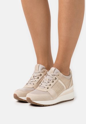 Chaussures de sport beiges en mesh et daim, avec des accents perforés, des lacets plats et une semelle compensée pour plus de hauteur.