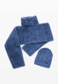 Sinine udune sall ja mütsikomplekt. Sallil on kõrge kaelus ja tekstureeritud pind. Müts on ümmarguse kujuga, pehme kangaga ja väike aktsentauguga.