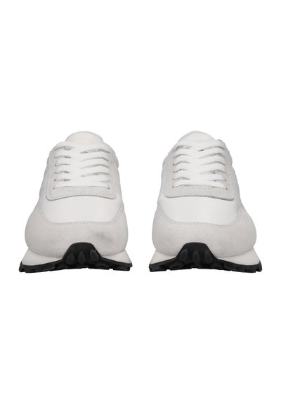 Weiße Sneaker aus Leder und Wildleder, mit runden Schnürsenkeln, einer strukturierten Oberfläche und einer schwarzen Gummisohle mit kreisförmigen Profilmustern.