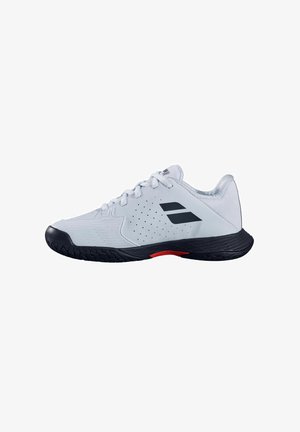 Zapatilla deportiva blanca con suela negra, logo negro en el lateral, cordones blancos y detalle rojo en la suela, mostrada de lado.