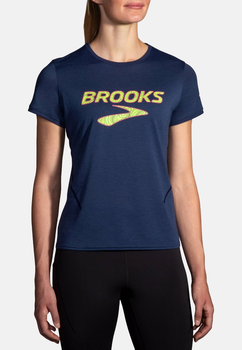 Tamsiai mėlynas sportinis marškinėliai trumpomis rankovėmis ir apvalia iškirpte. Su ryškiai geltonu "BROOKS" logotipu ir grafiniu dizainu.