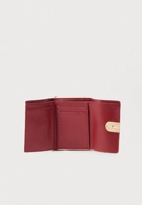 Trijų dalių raudonos odos piniginė atidaryta, matomos kortelių ertmės, viršuje esanti užsegama monetų kišenė ir auksinė sagtis dešinėje pusėje.