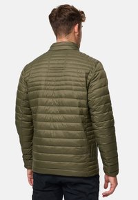 Olivengrøn, kviltet pufferjakke med opretstående krave og lange ærmer. Har horisontale syninger og en glat, skinnende tekstur.