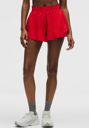 Rote athletische Shorts aus leichtem Stoff, mit einem breiten Bund und zwei Seitentaschen, im lockeren, fließenden Design.