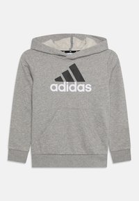 Grauer Kapuzenpullover aus Baumwolle mit einer vorderen Kängurutasche. Auf der Brust befindet sich ein großes schwarz-weißes Adidas-Logo.