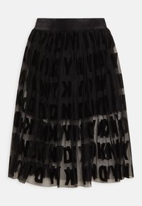 Černá sukni z více vrstev tylu s elastickým pasem, na které jsou výrazné, rozmístěné černé písmena tvořící grafický textový vzor.
