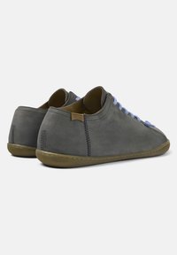 Scarpe in suede grigio con lacci blu chiaro, forma arrotondata, superficie testurizzata e suola in gomma marrone. Logo Camper sul tallone.