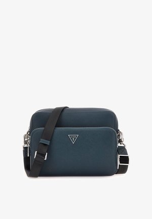 Sac bandoulière en faux cuir bleu sarcelle foncé avec quincaillerie argentée, comportant un compartiment zippé et une bandoulière noire réglable. Logo à l'avant.